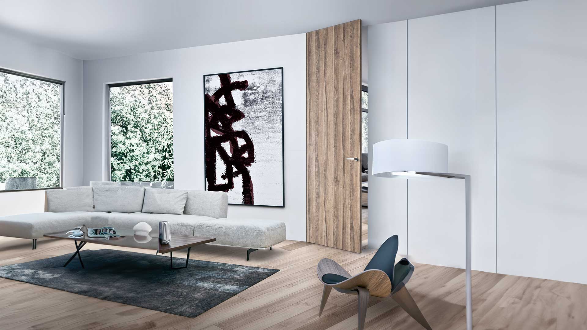 Living moderno e informale con collocazione di una porta filo muro a finitura Quercia della collezione MAGIK del marchio IDOOR